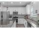 The bright kitchen features stainless appliances, granite counters and a view of the backyard at 1214 Valley Dale Dr, Fuquay Varina, NC 27526