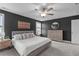 Bright carpeted main bedroom features a light grey accent wall, ceiling fan, dresser, and large windows at 1214 Valley Dale Dr, Fuquay Varina, NC 27526