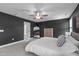 Spacious main bedroom featuring dark accent wall, carpet floors, modern ceiling fan, and a large mirror at 1214 Valley Dale Dr, Fuquay Varina, NC 27526