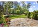Stone patio and manicured backyard featuring an ornamental wrought iron fence and lush landscaping at 122 Glenpark Pl, Cary, NC 27511