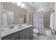 Well-lit bathroom with a vanity, large mirror, shower and tile floors at 122 Glenpark Pl, Cary, NC 27511