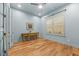 Light filled bedroom features wood floors, plantation shutters, and blue painted walls at 122 Glenpark Pl, Cary, NC 27511