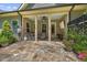 Inviting covered patio featuring a stone floor, fan, and seating area, ideal for relaxation at 122 Glenpark Pl, Cary, NC 27511