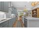 Open kitchen with gray cabinets, quartz countertops, and stainless steel appliances at 122 Glenpark Pl, Cary, NC 27511