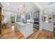 Kitchen with wood floors, gray cabinets, large island, stainless appliances, and modern lighting at 122 Glenpark Pl, Cary, NC 27511