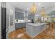Spacious kitchen featuring modern light fixtures, center island, and stainless steel appliances at 122 Glenpark Pl, Cary, NC 27511