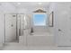 Elegant bathroom featuring glass shower, soaking tub, and bright, diamond pane window at 122 Glenpark Pl, Cary, NC 27511