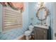 Stylish powder room with bee-themed wallpaper, ornate mirror, and wood-look vanity at 122 Glenpark Pl, Cary, NC 27511