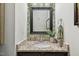 Bathroom with granite countertop vanity, decorative mirror, and leaf-patterned wallpaper at 12620 Waterlow Park Ln, Raleigh, NC 27614