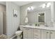 Bright bathroom featuring double sinks with marble countertops, modern fixtures and decorative wallpaper at 12620 Waterlow Park Ln, Raleigh, NC 27614