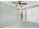 This is a cozy carpeted bedroom with a ceiling fan and double door closet at 12620 Waterlow Park Ln, Raleigh, NC 27614