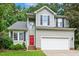 Charming two-story home with gray siding, black shutters, a red door, and an attached two-car garage at 12620 Waterlow Park Ln, Raleigh, NC 27614