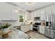 Bright kitchen features stainless appliances, and stylish white cabinetry at 12620 Waterlow Park Ln, Raleigh, NC 27614