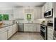 Charming kitchen with white cabinetry, subway tile backsplash, and modern stainless steel appliances at 12620 Waterlow Park Ln, Raleigh, NC 27614