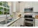 Bright kitchen with white cabinetry, stainless steel appliances, and natural light at 12620 Waterlow Park Ln, Raleigh, NC 27614