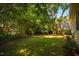 Lush backyard featuring mature trees, green lawn, and wooden fence at 13 Boxwood Dr, Durham, NC 27713