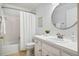 Clean bathroom features a shower-tub combination, white vanity, and round mirror, creating a fresh and functional space at 13 Boxwood Dr, Durham, NC 27713