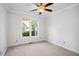 Cozy bedroom with ceiling fan, window, and neutral carpet, offering a serene and comfortable space at 13 Boxwood Dr, Durham, NC 27713
