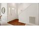 Bright foyer features a white front door with sidelights, hardwood floors, and staircase at 13 Boxwood Dr, Durham, NC 27713