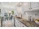Bright kitchen with granite countertops, subway tile backsplash, stainless appliances, and adjacent dining area at 13 Boxwood Dr, Durham, NC 27713