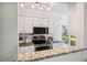 Well-lit kitchen features white cabinets, stainless steel appliances, and granite countertops, offering style and functionality at 13 Boxwood Dr, Durham, NC 27713