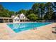 Community swimming pool surrounded by lush landscaping and trees at 13 Boxwood Dr, Durham, NC 27713