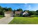 Inviting single-story home with a paved driveway, lush green lawn, and mature trees in the background at 131 Abacos Ct, Clayton, NC 27520