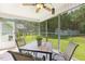 Well-lit screened porch overlooking green backyard with table and ceiling fan at 131 Abacos Ct, Clayton, NC 27520