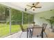 Enclosed porch with wooded view, ceiling fan, and outdoor dining area at 131 Abacos Ct, Clayton, NC 27520