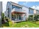 Spacious backyard with a covered patio, deck, lawn, and an iron fence at 1363 Brown Velvet Ln, Apex, NC 27523