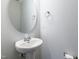 Contemporary powder room featuring a pedestal sink, round mirror, and modern fixtures at 1363 Brown Velvet Ln, Apex, NC 27523