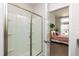 Ensuite bathroom featuring a glass enclosed shower and view of a bedroom. Modern and practical design at 1363 Brown Velvet Ln, Apex, NC 27523