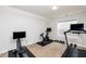 Home gym featuring various exercise equipment and neutral carpet with natural light through a window at 1363 Brown Velvet Ln, Apex, NC 27523