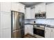 Bright kitchen showcasing stainless steel appliances, white cabinetry, and granite countertops at 1363 Brown Velvet Ln, Apex, NC 27523