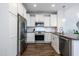 Contemporary kitchen featuring stainless steel appliances, white cabinets, and modern lighting at 1363 Brown Velvet Ln, Apex, NC 27523