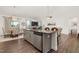 Open concept kitchen with gray cabinetry, granite counters, and seamless flow to dining and living areas at 1409 Sage Tree Dr, Zebulon, NC 27597