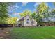 Spacious backyard with lush lawn, bordered by trees, a black fence and features a screened in back porch at 15 Cole Creek Way, Franklinton, NC 27525