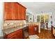Well-lit kitchen featuring granite countertops and wood cabinetry and flooring at 15 Cole Creek Way, Franklinton, NC 27525