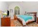 Cozy main bedroom with a king bed, a vaulted ceiling, and large arched window at 15 Cole Creek Way, Franklinton, NC 27525