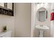Small powder room with pedestal sink and decorative mirror at 161 Jacob St, Holly Springs, NC 27540