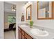 Bathroom featuring double sinks, granite countertop, wooden framed mirrors, and natural light at 161 Jacob St, Holly Springs, NC 27540
