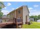 Expansive home exterior showcasing a wooden deck and well-maintained lawn with mature trees at 161 Jacob St, Holly Springs, NC 27540