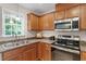 Bright kitchen features stainless steel appliances and wood cabinets with a window providing natural light at 161 Jacob St, Holly Springs, NC 27540