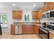 Well-lit kitchen features stainless steel appliances, wood cabinets, and a double sink overlooking the backyard at 161 Jacob St, Holly Springs, NC 27540