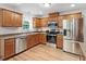 Kitchen with stainless steel appliances, sleek countertops, and wood cabinets at 161 Jacob St, Holly Springs, NC 27540
