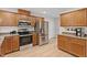Spacious kitchen featuring stainless steel appliances, ample wood cabinetry, and light wood flooring at 161 Jacob St, Holly Springs, NC 27540