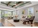 Bright and airy living room with a trey ceiling, modern sofa, and comfortable reading chair at 1633 Hillstar St, Fuquay Varina, NC 27526