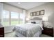 Bright bedroom featuring three windows, neutral walls, and a paisley patterned duvet at 196 Glen Hollow Dr, Raleigh, NC 27604