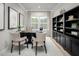 Well-lit home office featuring a large desk, built-in bookshelves, and serene outdoor views at 196 Glen Hollow Dr, Raleigh, NC 27604