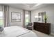 Bright bedroom featuring a large window, a comfortable chair, and an elegant dresser with a mirror at 197 Glen Hollow Dr, Raleigh, NC 27604